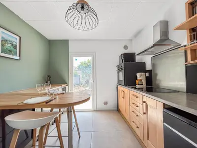 a kitchen with a wooden table and a dining room at Maison avec Jardin, Terrasse, cheminée insert et bois in Carcassonne
