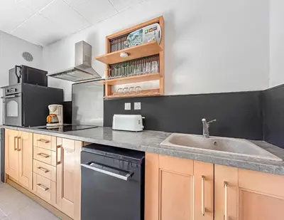 a kitchen with a sink and a stove at Maison avec Jardin, Terrasse, cheminée insert et bois in Carcassonne