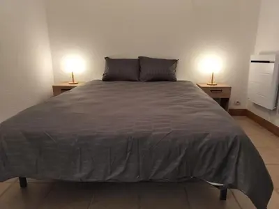 a bedroom with a large bed with two lamps on tables at Apartment 6 in Castelnaudary