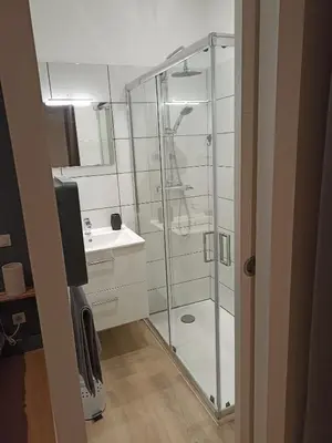 a bathroom with a glass shower and a sink at Chambre avec salle de bain privative in Castres