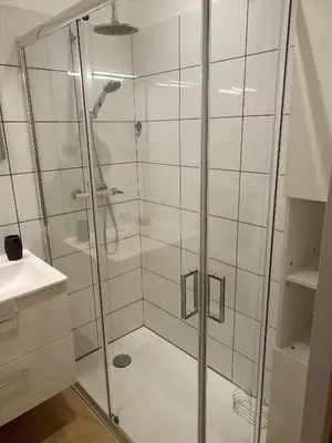 a shower with a glass door in a bathroom at Chambre avec salle de bain privative in Castres