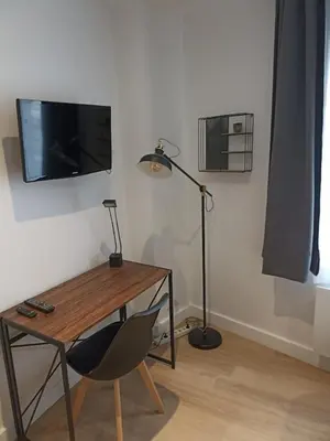 a room with a desk and a lamp and a chair at Chambre avec salle de bain privative in Castres