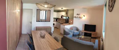 a living room with a dining table and a kitchen at Chambre avec salle de bain privative in Castres