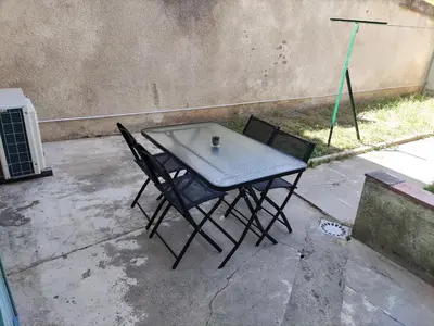 a table and chairs with a cup on top of it at Chambre avec salle de bain privative in Castres