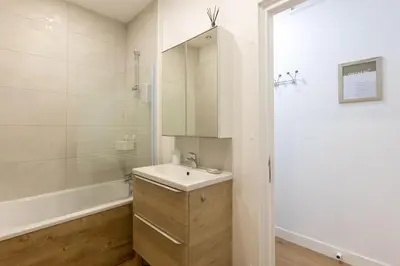 a bathroom with a sink and a tub and a mirror at Grand Studio Centre Castres in Castres