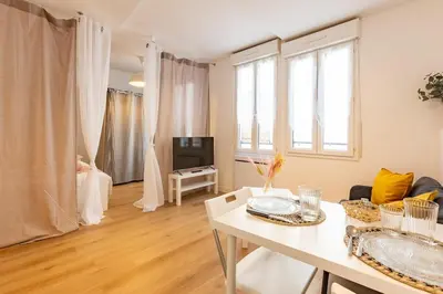 a living room with a white table and a tv at Grand Studio Centre Castres in Castres