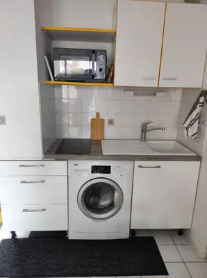 a kitchen with a washing machine and a microwave at Le Thalassa II in Gruissan
