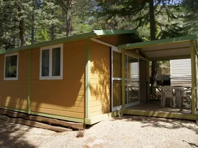 a small cabin with a porch and a patio at Chalet confortable avec terrasse à Sournia - API-1-52-491 in Sournia
