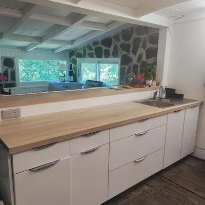 a kitchen with white cabinets and a wooden counter top at Chalet atypique in Anglès
