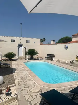 a swimming pool in a yard with a patio at La villa des lauriers in Cuxac-dʼAude