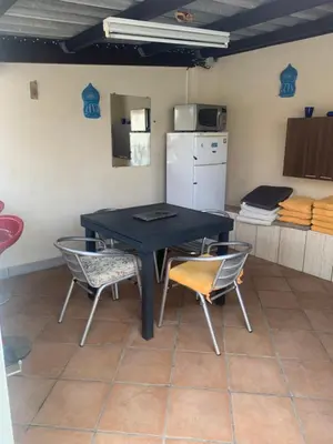 a kitchen with a table and chairs and a refrigerator at La villa des lauriers in Cuxac-dʼAude