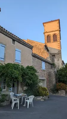 a building with a table and chairs in front of it at Charmante maison de village à Tourouzelle in Tourouzelle