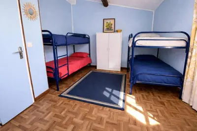 a room with two bunk beds and a rug at Charmante maison de village à Tourouzelle in Tourouzelle