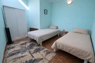 two beds in a room with blue walls at Charmante maison de village à Tourouzelle in Tourouzelle