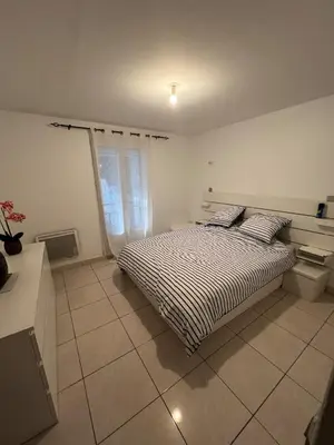 a bedroom with a bed and a window at T2 apartment, terrasse cours intérieur in Narbonne
