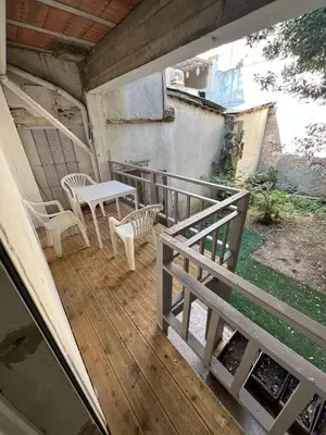 a porch with a table and chairs on a balcony at T2 apartment, terrasse cours intérieur in Narbonne
