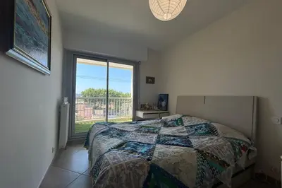 a bedroom with a bed and a large window at Apartment with view quiet and comfort in Narbonne in Narbonne