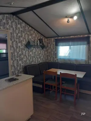a living room with a couch and a table and chairs at Mobil Home La Belle Vie in Vaudreuille