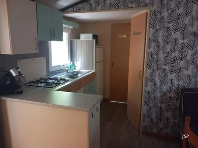 a kitchen with a stove and a refrigerator at Mobil Home La Belle Vie in Vaudreuille