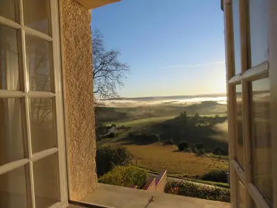 an open window with a view of a foggy field at Chambre des Remparts in Lautrec