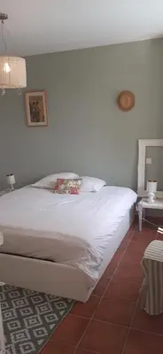 a bedroom with a white bed and a table at Chambre des Remparts in Lautrec
