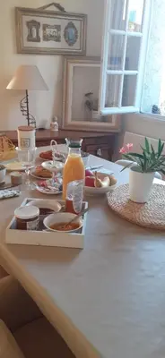 a table with a tray of food and a jug of orange juice at Chambre des Remparts in Lautrec