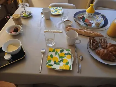 a table with plates of food and utensils on it at Chambre des Remparts in Lautrec