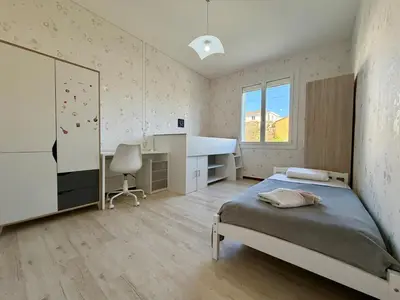 a bedroom with a bed and a desk in it at L'Horizon de la Cité in Carcassonne
