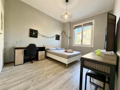 a bedroom with a bed and a desk and a computer at L'Horizon de la Cité in Carcassonne
