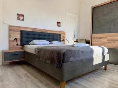 a bedroom with a large bed with a blue headboard at L'Horizon de la Cité in Carcassonne