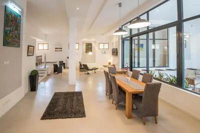 a dining room and living room with a table and chairs at l'Ecrit Vin in Rustiques