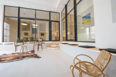 a lobby with chairs and tables and windows at l'Ecrit Vin in Rustiques