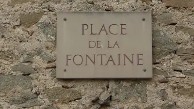 a sign that reads place de la tortume on a stone wall at l'Ecrit Vin in Rustiques