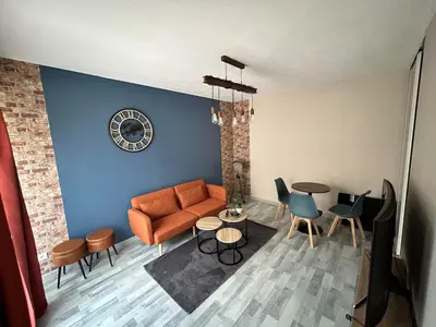 a living room with a couch and a table and chairs at Appartement au calme commerces à proximité in Castres