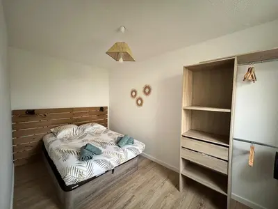 a small bedroom with a bed and a shelf at Appartement au calme commerces à proximité in Castres