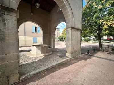 a stone archway with a bench in a courtyard at Appartement au calme commerces à proximité in Castres