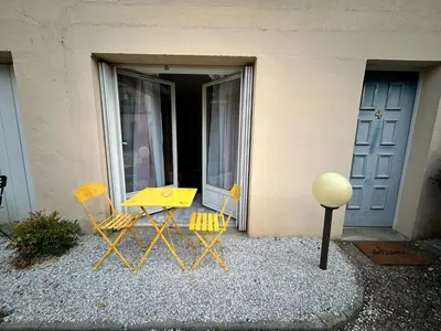 two chairs and a yellow table in front of a building at Appartement au calme commerces à proximité in Castres