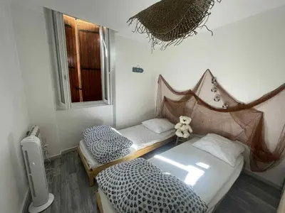two twin beds in a room with a window at Le Nid du Peintre in Narbonne