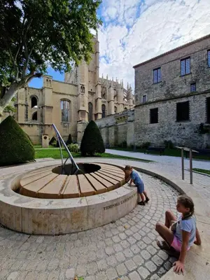 a boy and a girl sitting in front of a fountain at Le Nid du Peintre in Narbonne