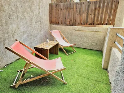 two lawn chairs and a table on the grass at Le Nid du Peintre in Narbonne