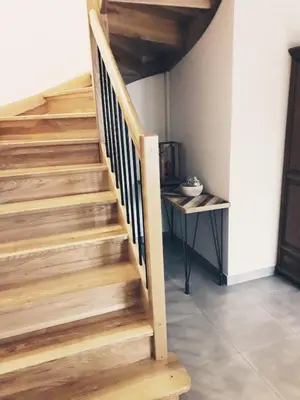 a wooden staircase in a room with a table at Domaine Fontgrande Gîte in Carcassonne