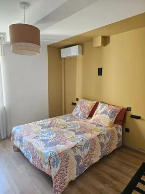 a bedroom with a bed with a colorful comforter at Les Oreillers Multicolores in Castelnau-dʼAude