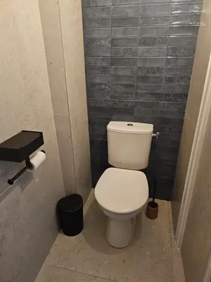 a bathroom with a white toilet in a stall at Les Oreillers Multicolores in Castelnau-dʼAude