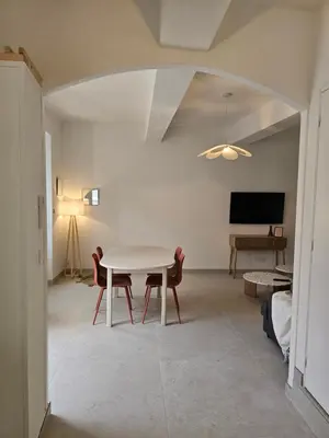 a living room with a white table and chairs at Les Oreillers Multicolores in Castelnau-dʼAude