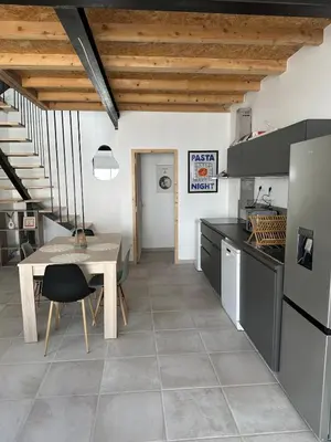 a kitchen with a table and a dining room at Le Riquet Duplex neuf climatisé au calme in Carcassonne