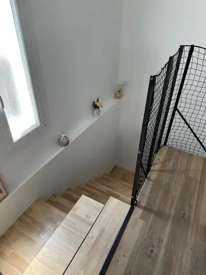 a white room with a staircase and a window at Le Riquet Duplex neuf climatisé au calme in Carcassonne