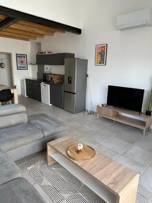 a living room with a couch and a table at Le Riquet Duplex neuf climatisé au calme in Carcassonne