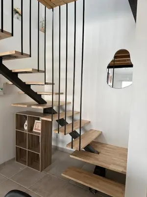 a wooden staircase with black railings in a room at Le Riquet Duplex neuf climatisé au calme in Carcassonne