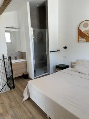a bedroom with a white bed and a shower at Le Riquet Duplex neuf climatisé au calme in Carcassonne