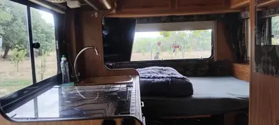 a room with a bed and a window in an rv at Le camping-car de la Gardié in Vielmur-sur-Agout